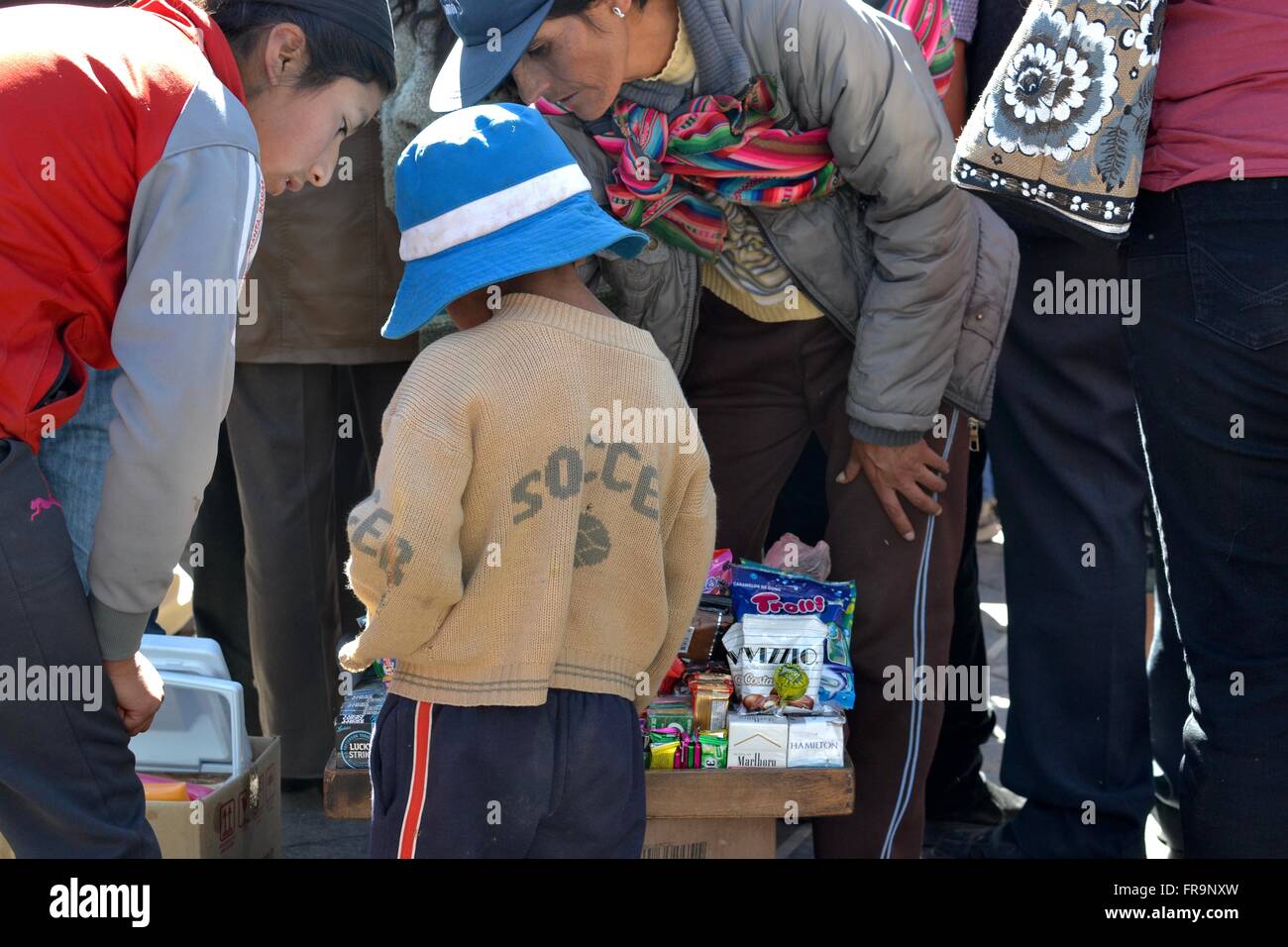 Ragazzo acquisto di caramelle in Cusco durante il Corpus Christi massa esterna Foto Stock