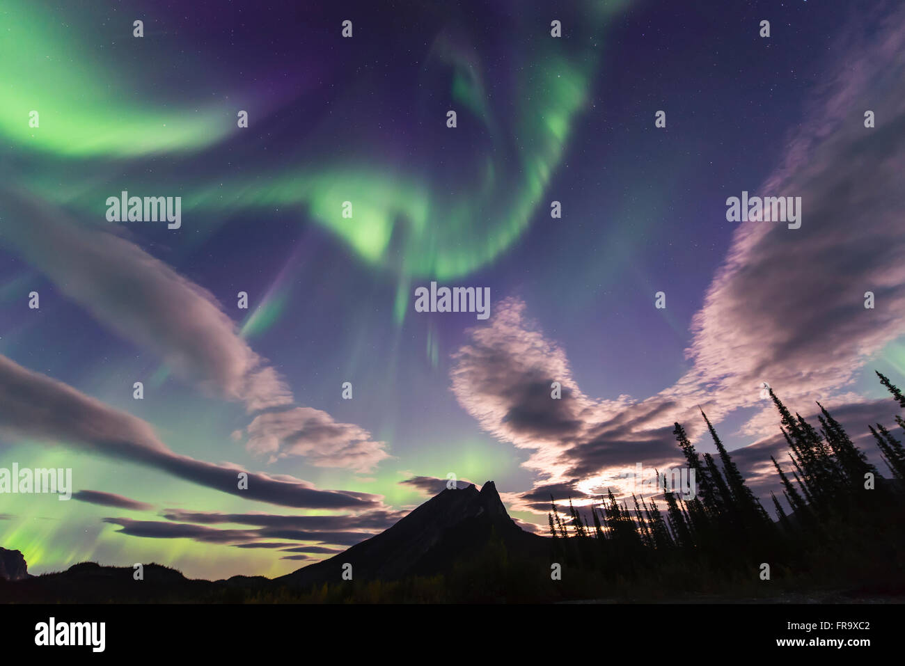 L'aurora boreale e nuvole di condividere il cielo sopra il Mt. Sukakpak in Brooks Range a nord di Wiseman, Arctic Alaska. Foto Stock