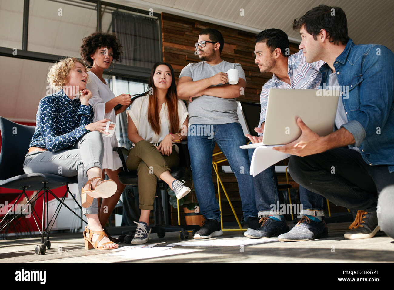 Team di persone creative discutendo circa il nuovo progetto. Diversi gruppi di giovani aventi un incontro presso l'ufficio. Foto Stock