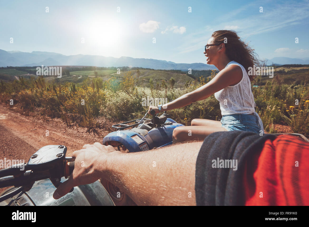 I giovani la guida quad bikes su un giorno d'estate. Donna Paese godendo di corsa su un veicolo fuoristrada. POV shot. Foto Stock