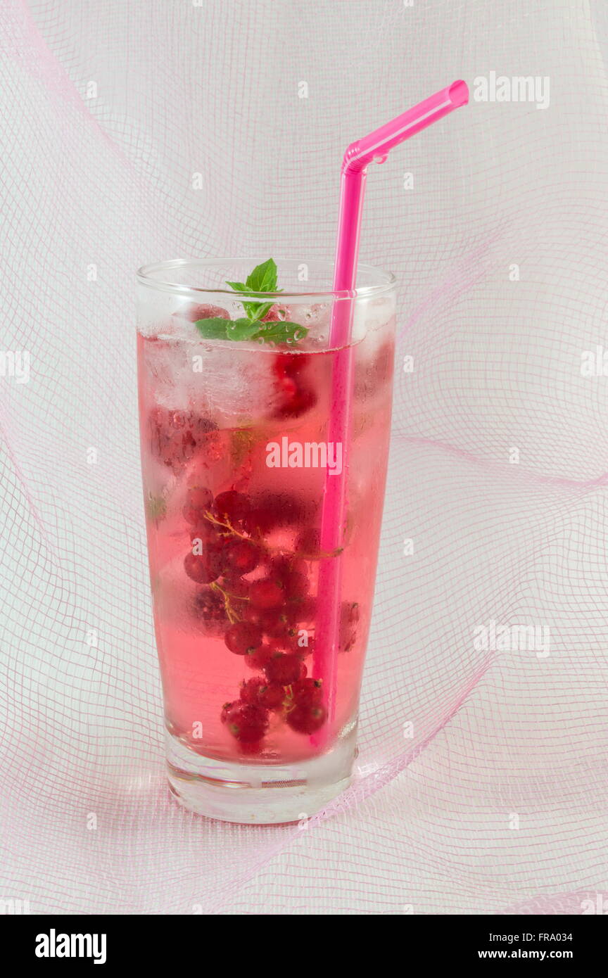 Di succo di frutti di bosco con cubetti di ghiaccio contro soft sfondo rosa Foto Stock