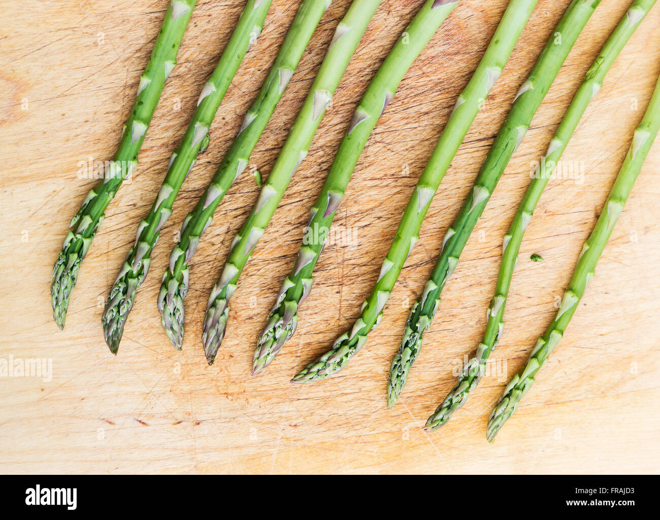 I germogli di asparagi, Asparagus officinalis, su un tagliere di legno. Foto Stock