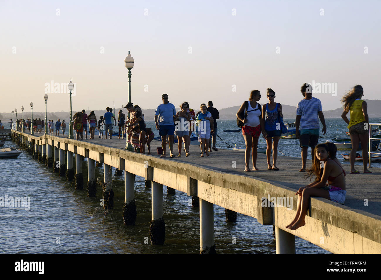 I turisti a piedi nel tardo pomeriggio presso il molo della spiaggia di Manguinhos a guardare il tramonto Foto Stock