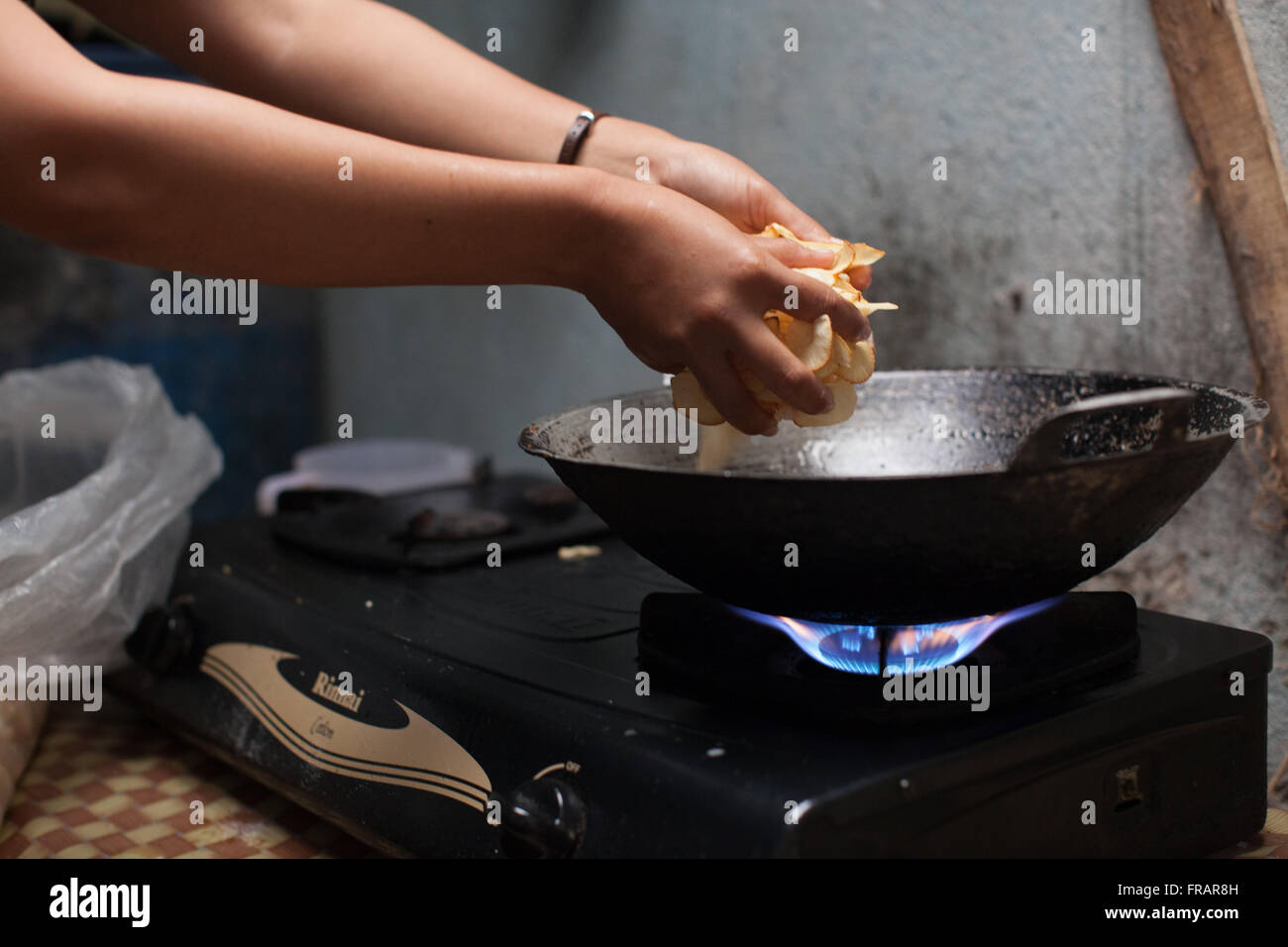 Una donna la sua cottura in casa le patatine che lei vende per vivere, Indonesia Foto Stock