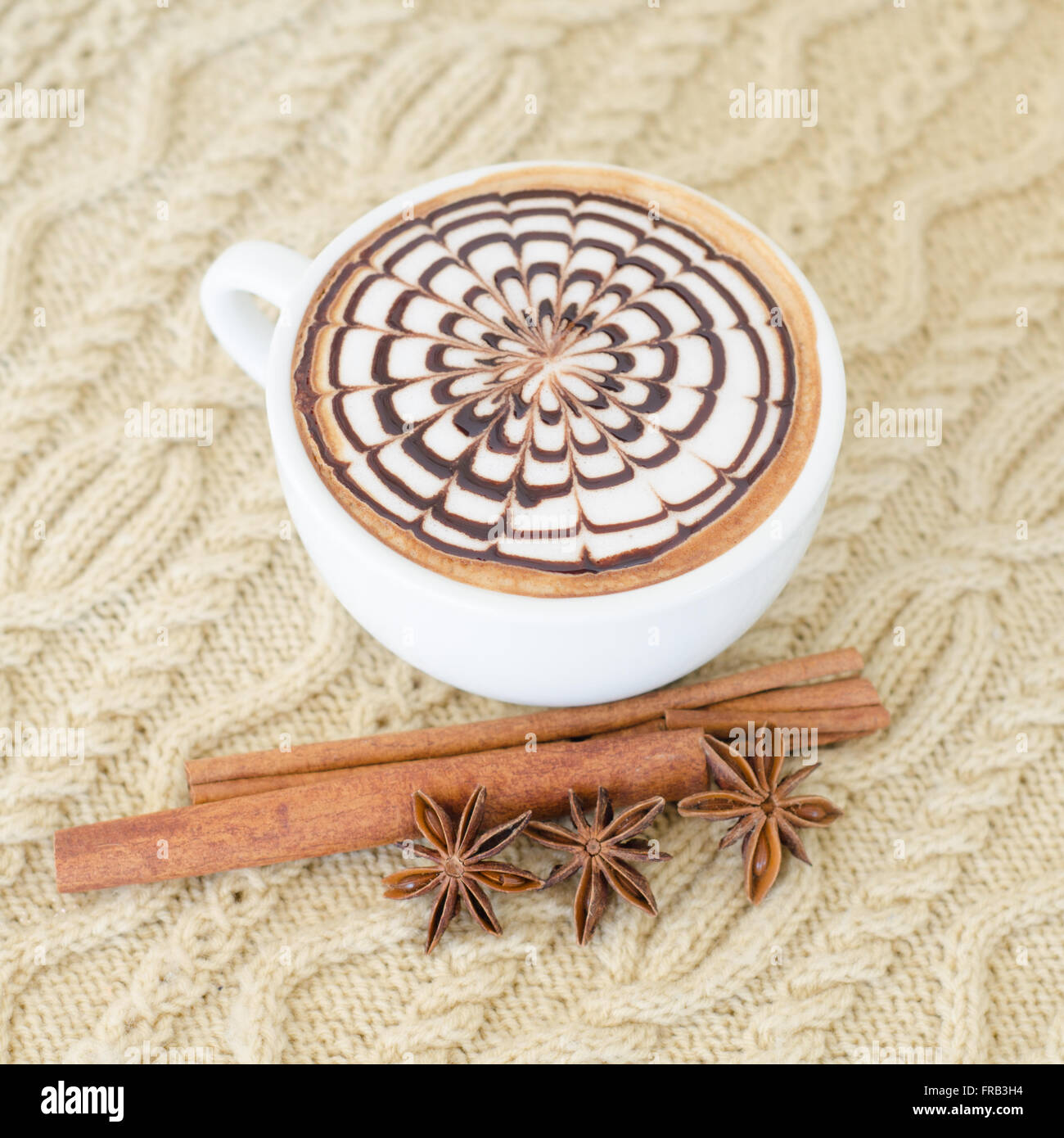 Una tazza di latte art su uno sfondo a maglia Foto Stock