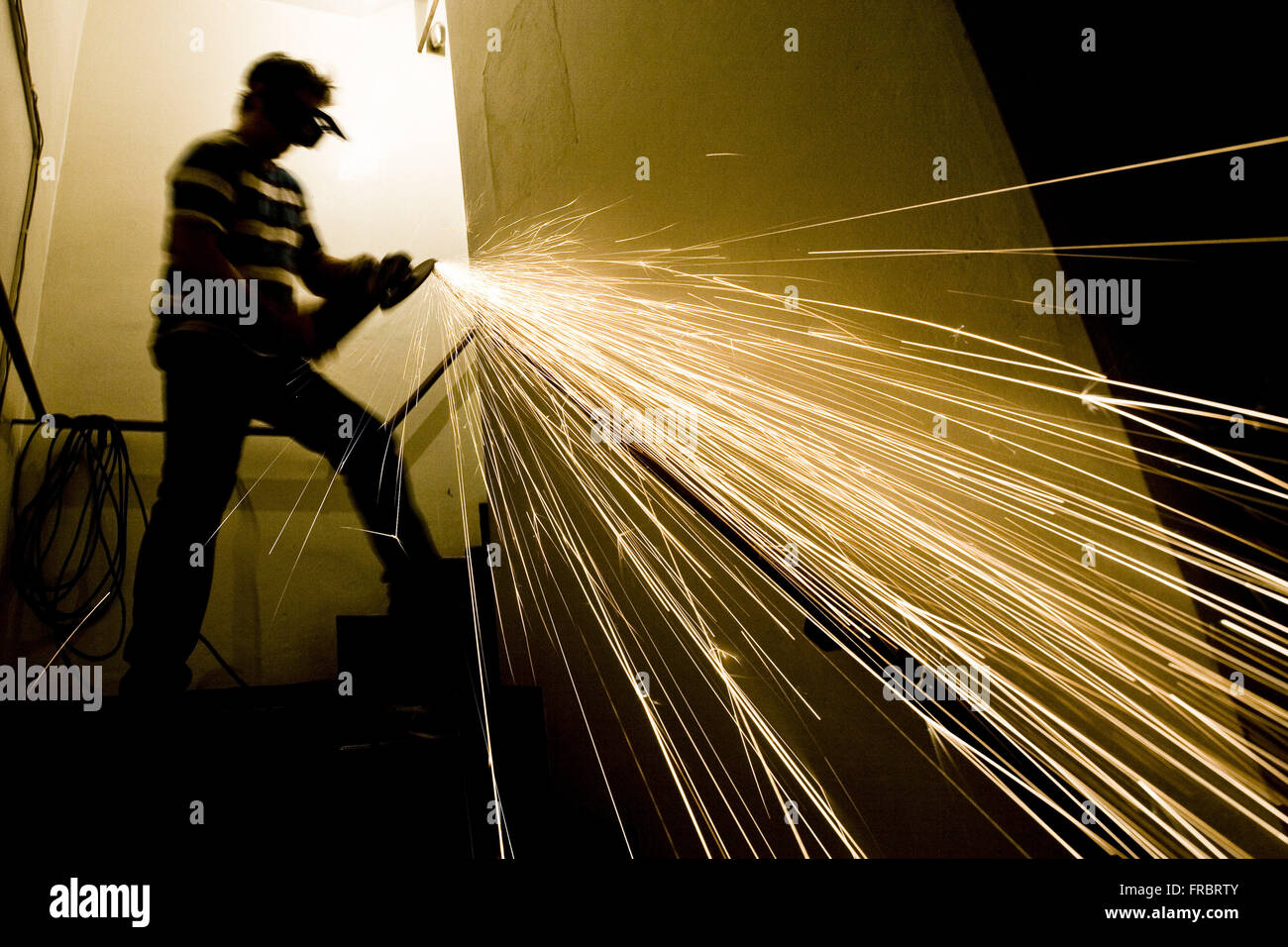 Workman mediante tela smeriglio per fissare il corrimano scale edificio residenziale Foto Stock