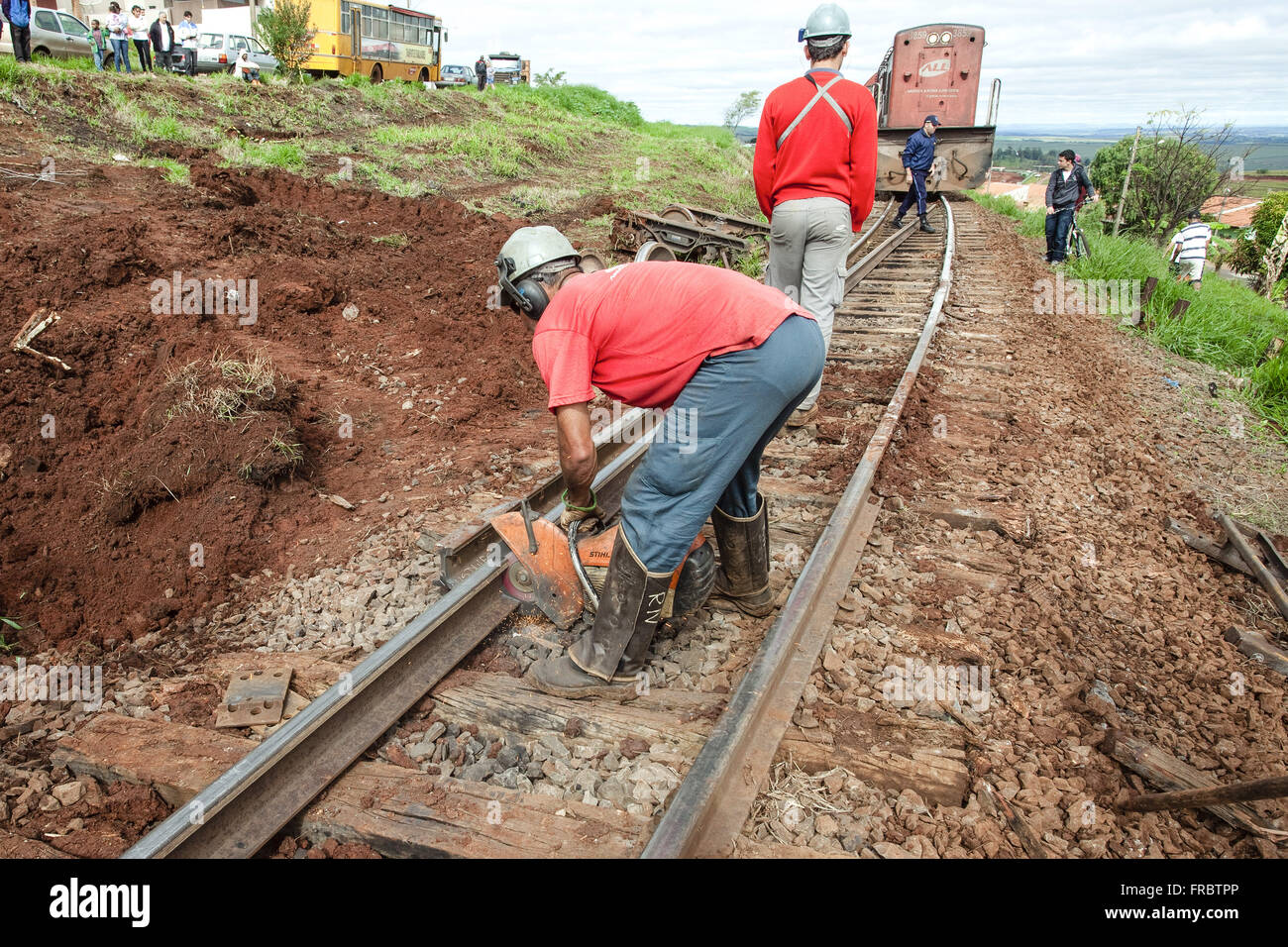 Operai che lavorano sulla via di recupero dopo il deragliamento del treno Foto Stock