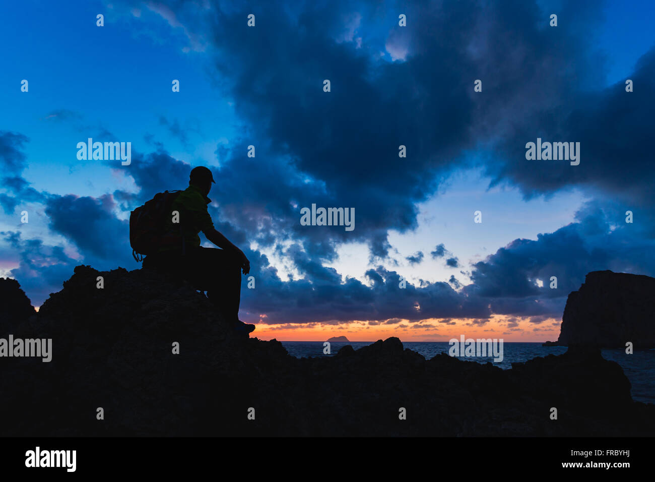 Escursionista o runner silhouette backpacker, un uomo in cerca di ispirazione paesaggio oceano e isole sul picco di montagna. Compiuta m Foto Stock