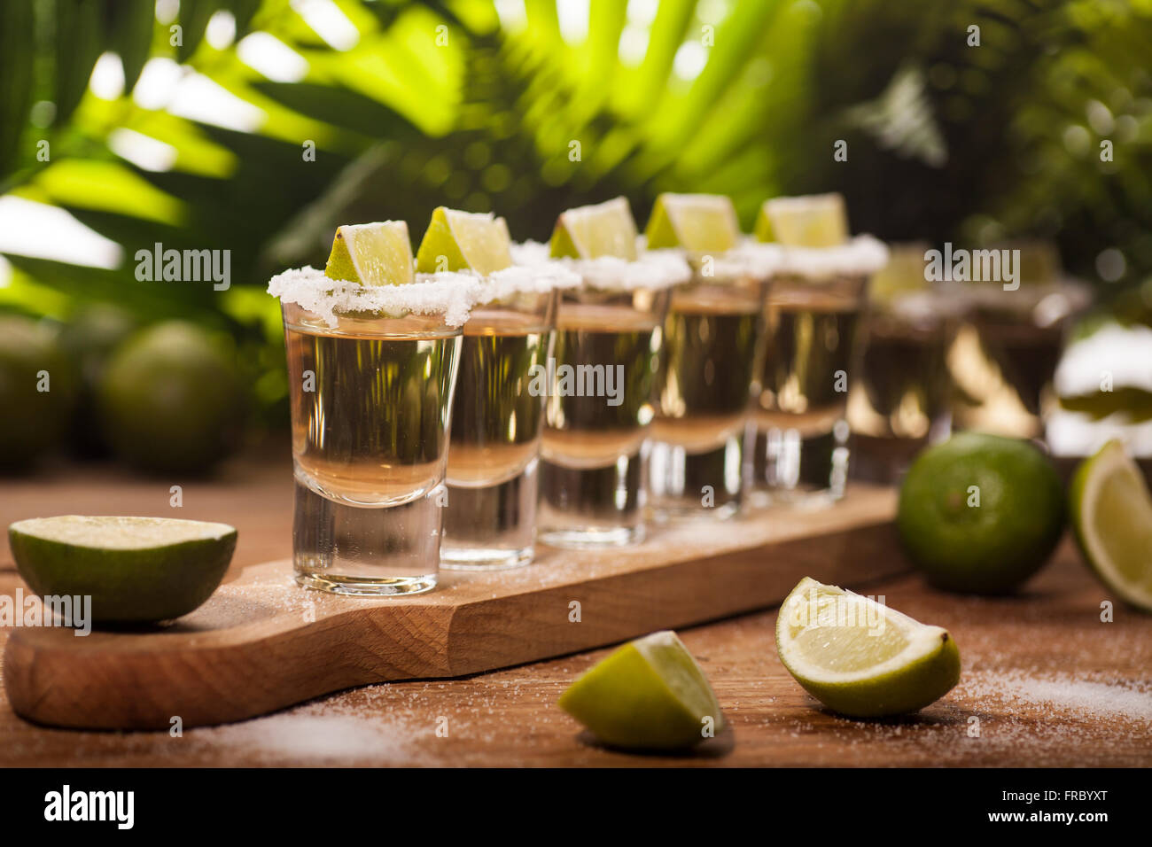 Oro tequila scatti con frutti di lime Foto Stock