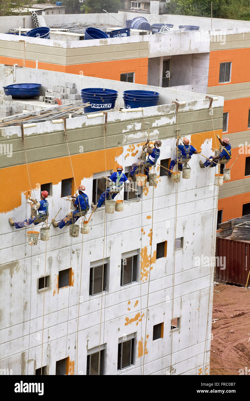 Lavoratori che svolgono dipinto esterno Itaoca condominio Sviluppo di alloggiamento Foto Stock