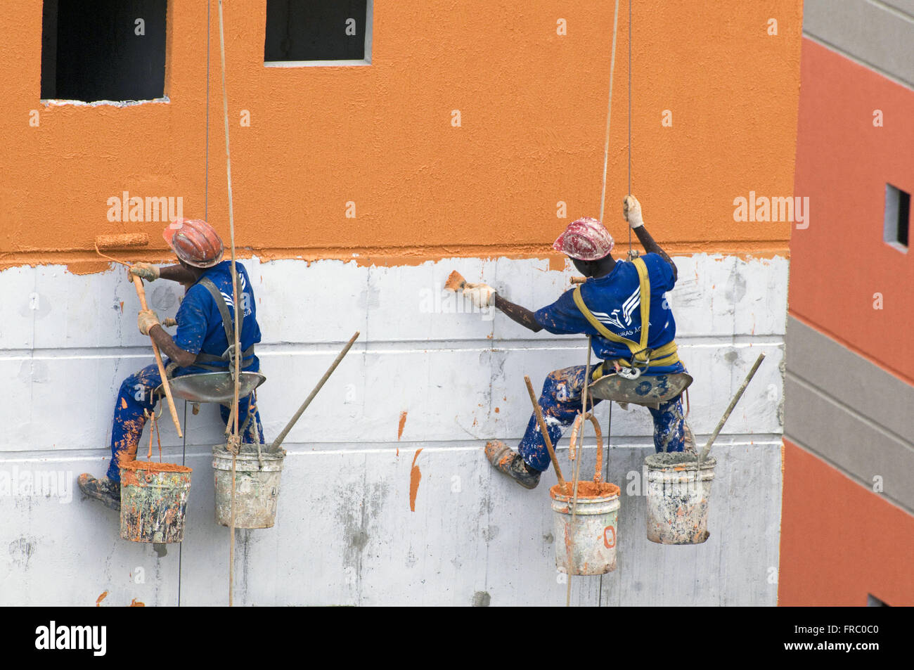 Lavoratori che svolgono dipinto esterno Itaoca condominio Sviluppo di alloggiamento Foto Stock