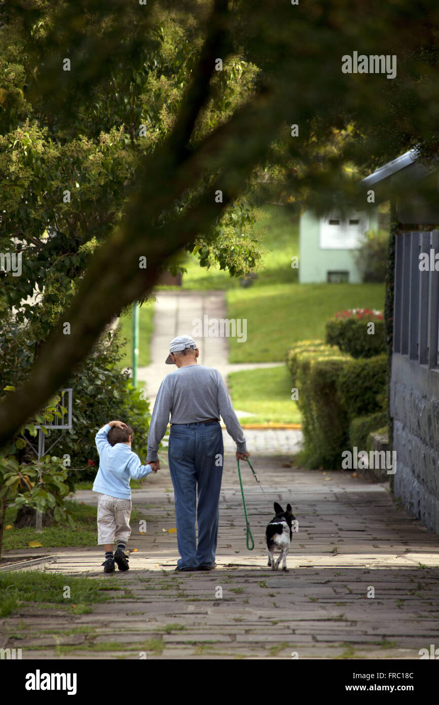 Anziani a piedi con bambino e cane nella città di Canela Foto Stock