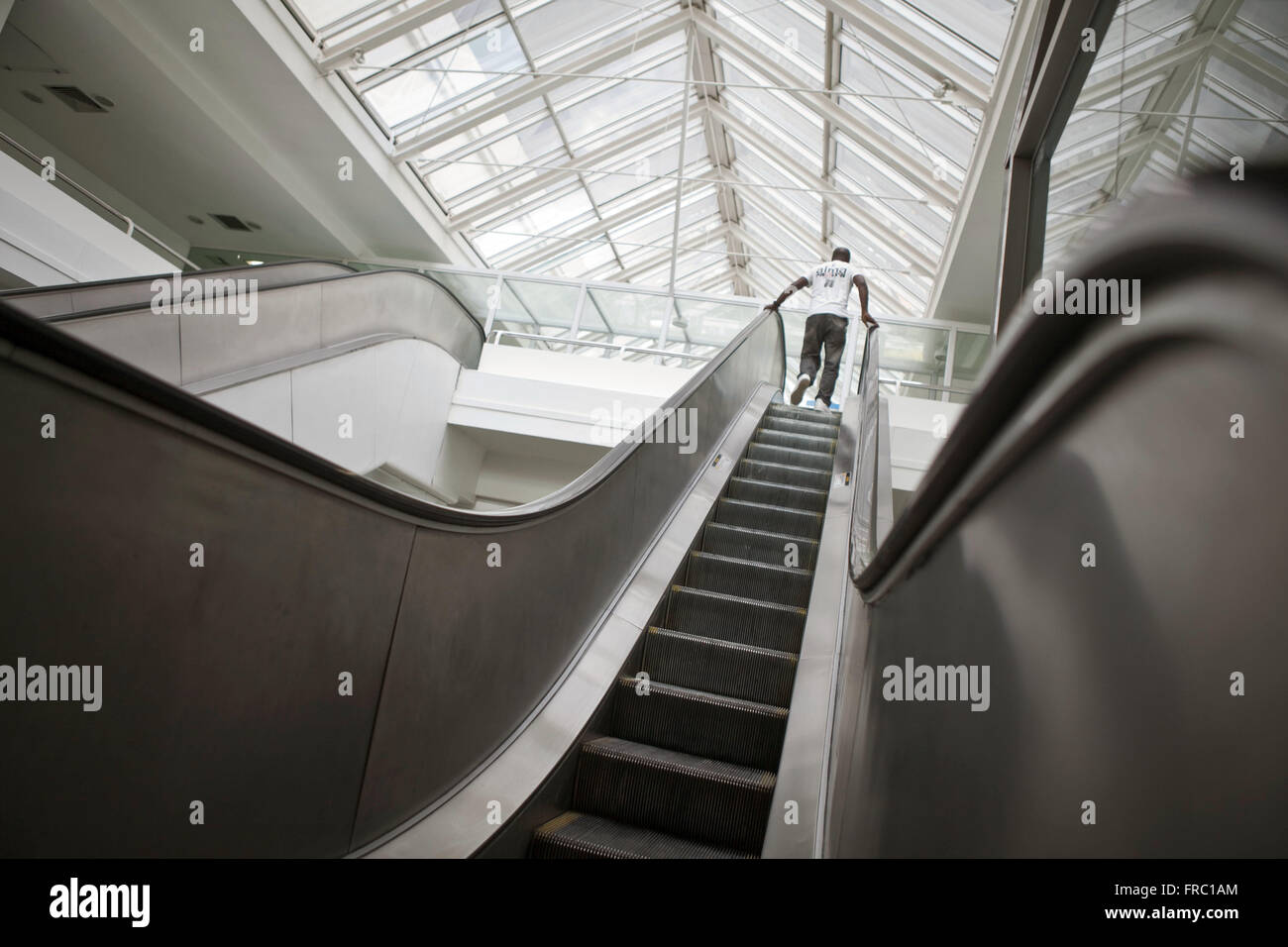 Uomo sulla scala mobile shopping centre nel nord della città di Rio de Janeiro Foto Stock