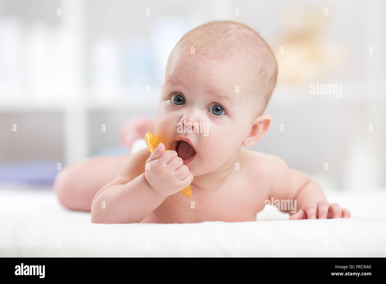 Baby bambino giacente sulla pancia usurata con il succhietto nella bocca Foto Stock