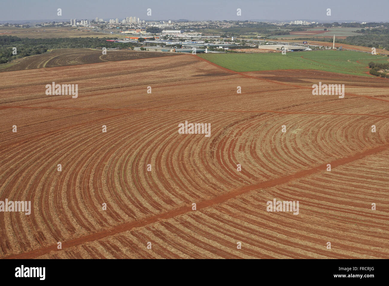 Vista aerea di terreno arato per la piantagione di zucchero di canna in campagna - lo sfondo area urbana Foto Stock