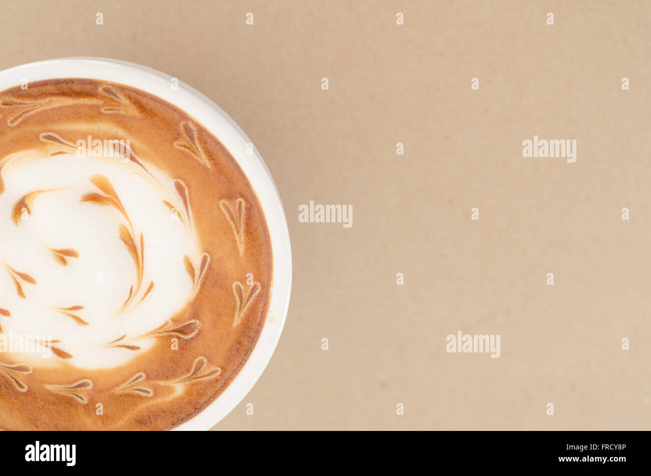 Una tazza di latte art su carta marrone sfondo Foto Stock