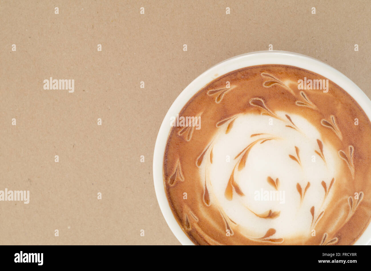 Una tazza di latte art su carta marrone sfondo Foto Stock