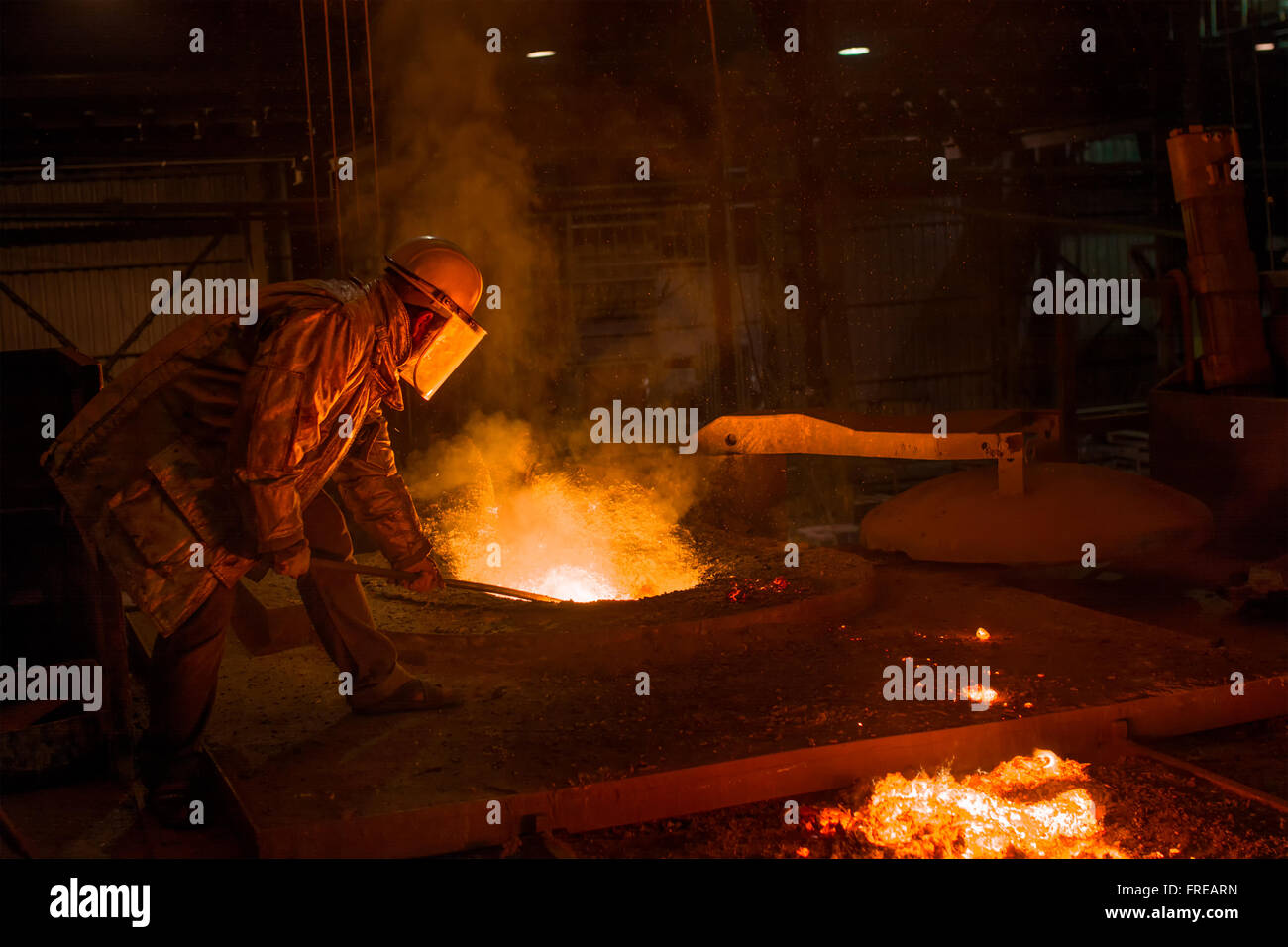 Il duro lavoro in una fonderia di ferro di fusione Foto Stock