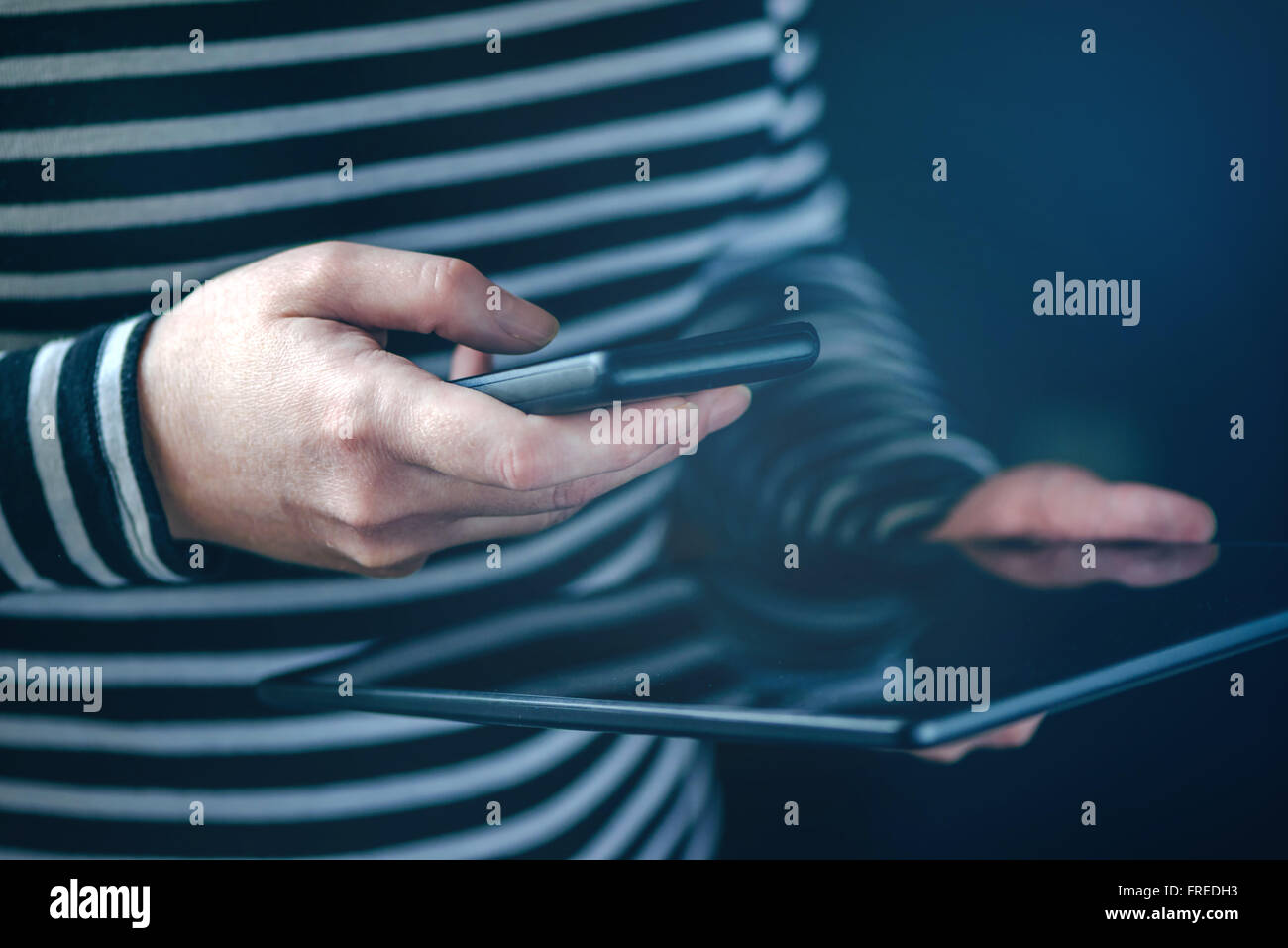 Smartphone e Tablet la sincronizzazione dei dati, la donna la sincronizzazione di file e documenti su personal wireless dispositivi elettronici a casa, s Foto Stock