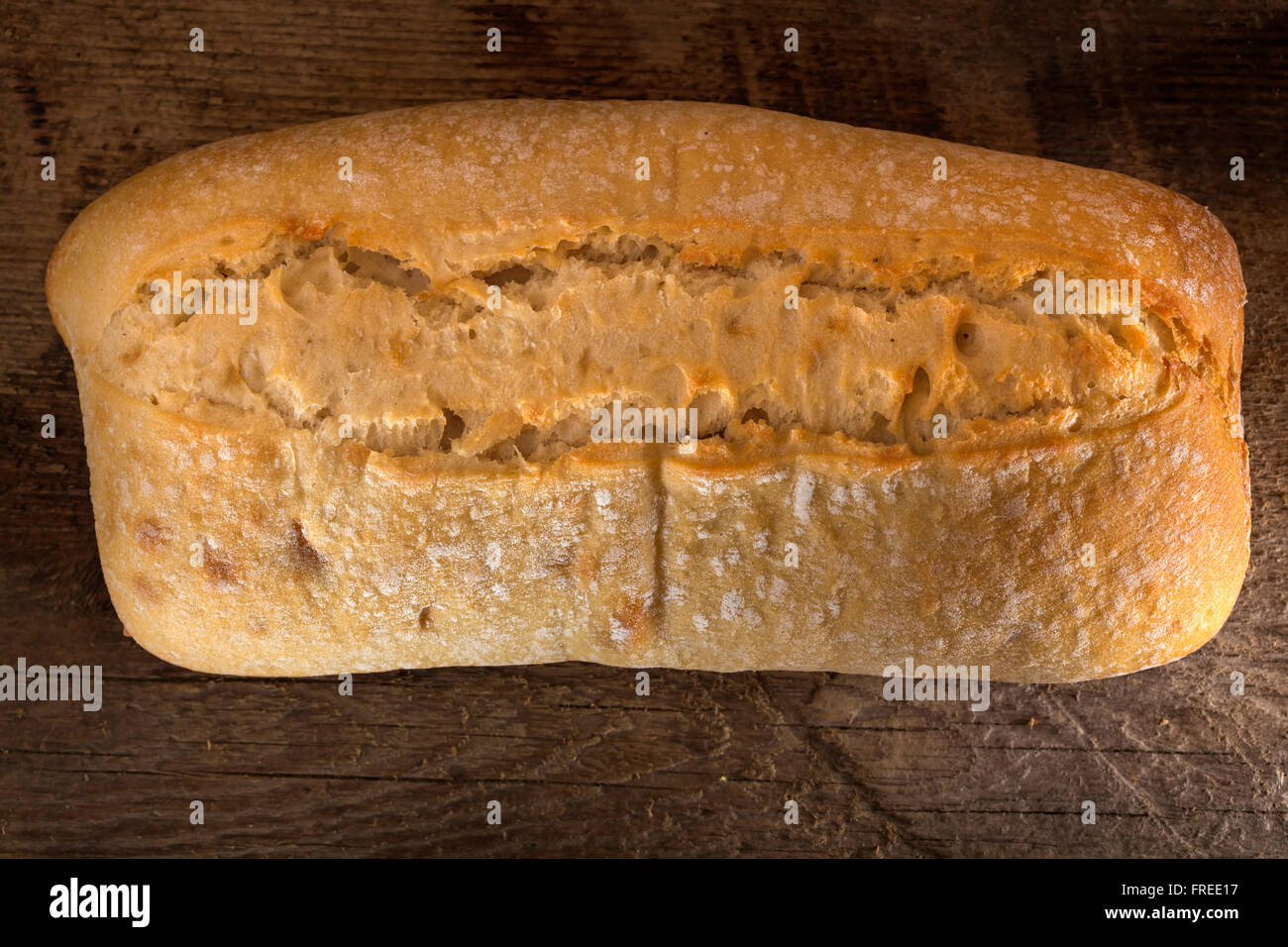 Filone di pane su un vecchio rustico sfondo di legno Foto Stock