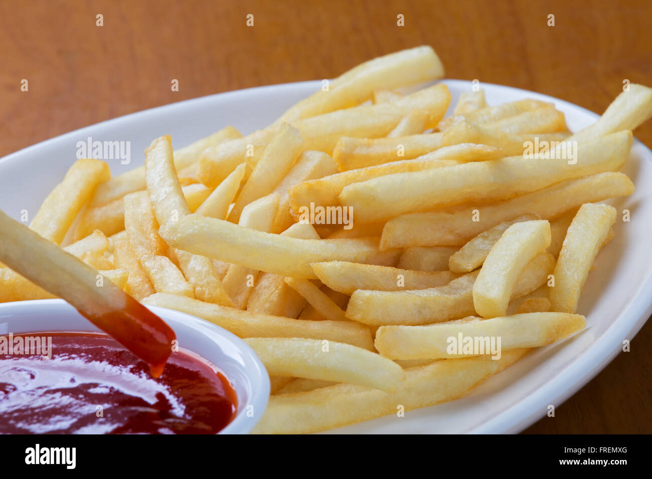 Una piastra piena di delizioso stile shoestring patate fritte con ketchup Foto Stock
