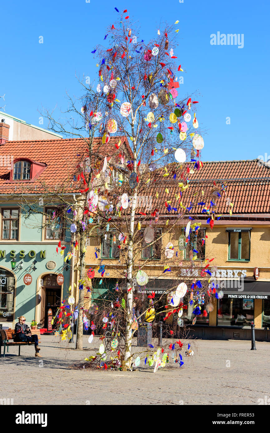 Kalmar, Svezia - 17 Marzo 2016: Una betulla è stata decorata con le piume e le uova di carta e posto su una piazza cittadina di cel Foto Stock