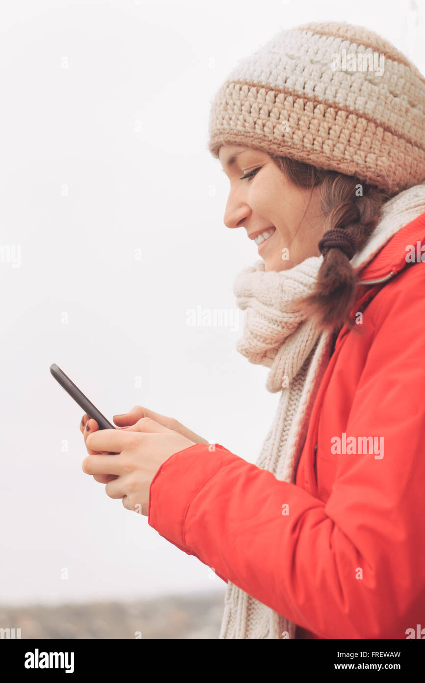 Giovane donna digitando messaggio sul telefono intelligente Foto Stock