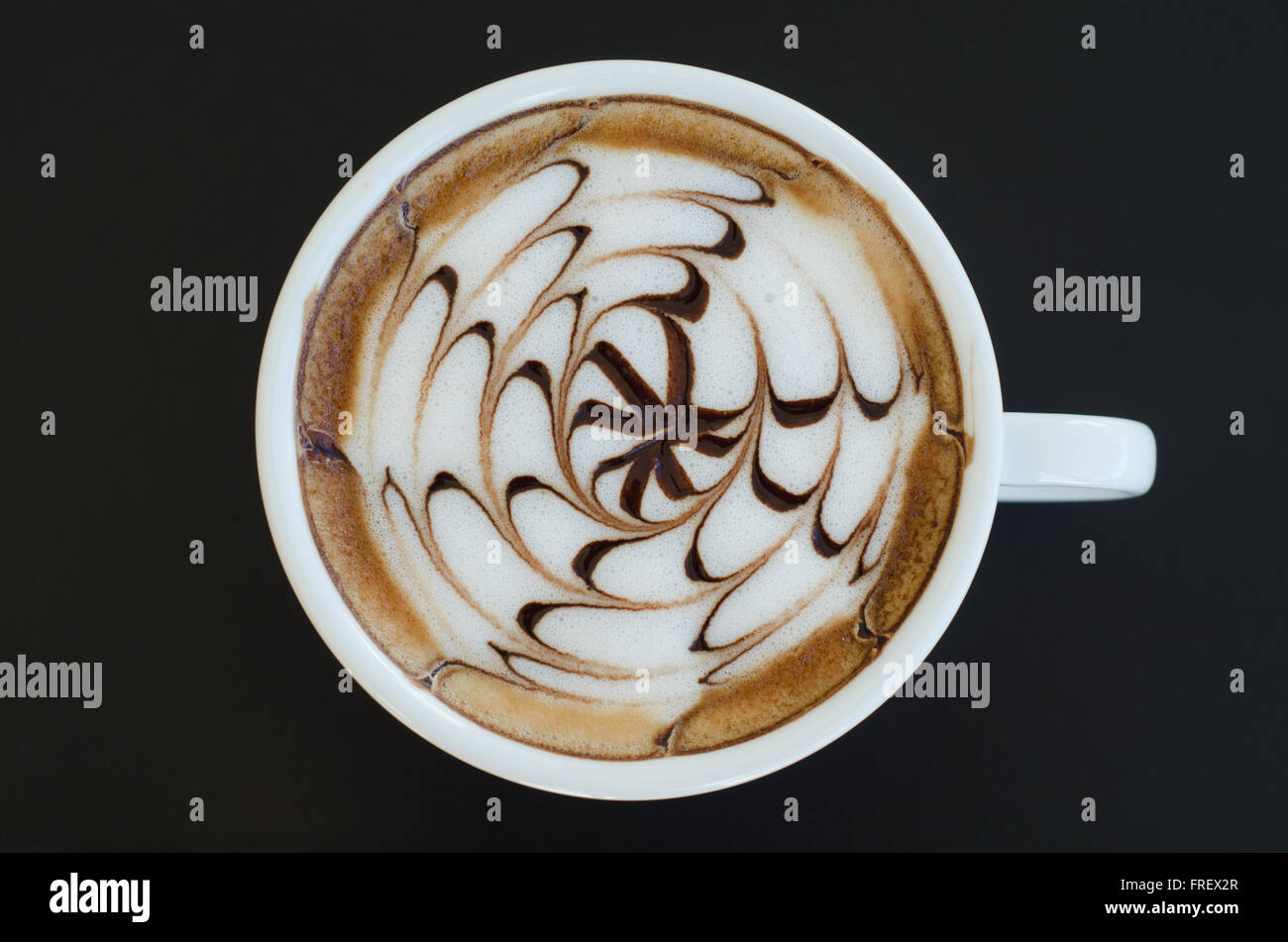 Una tazza di latte art su sfondo nero Foto Stock