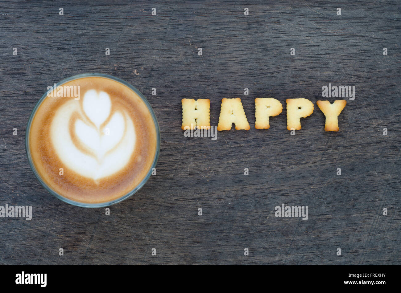 Una tazza di latte art e alphabet 'felice ' realizzato dal pane di cookie Foto Stock