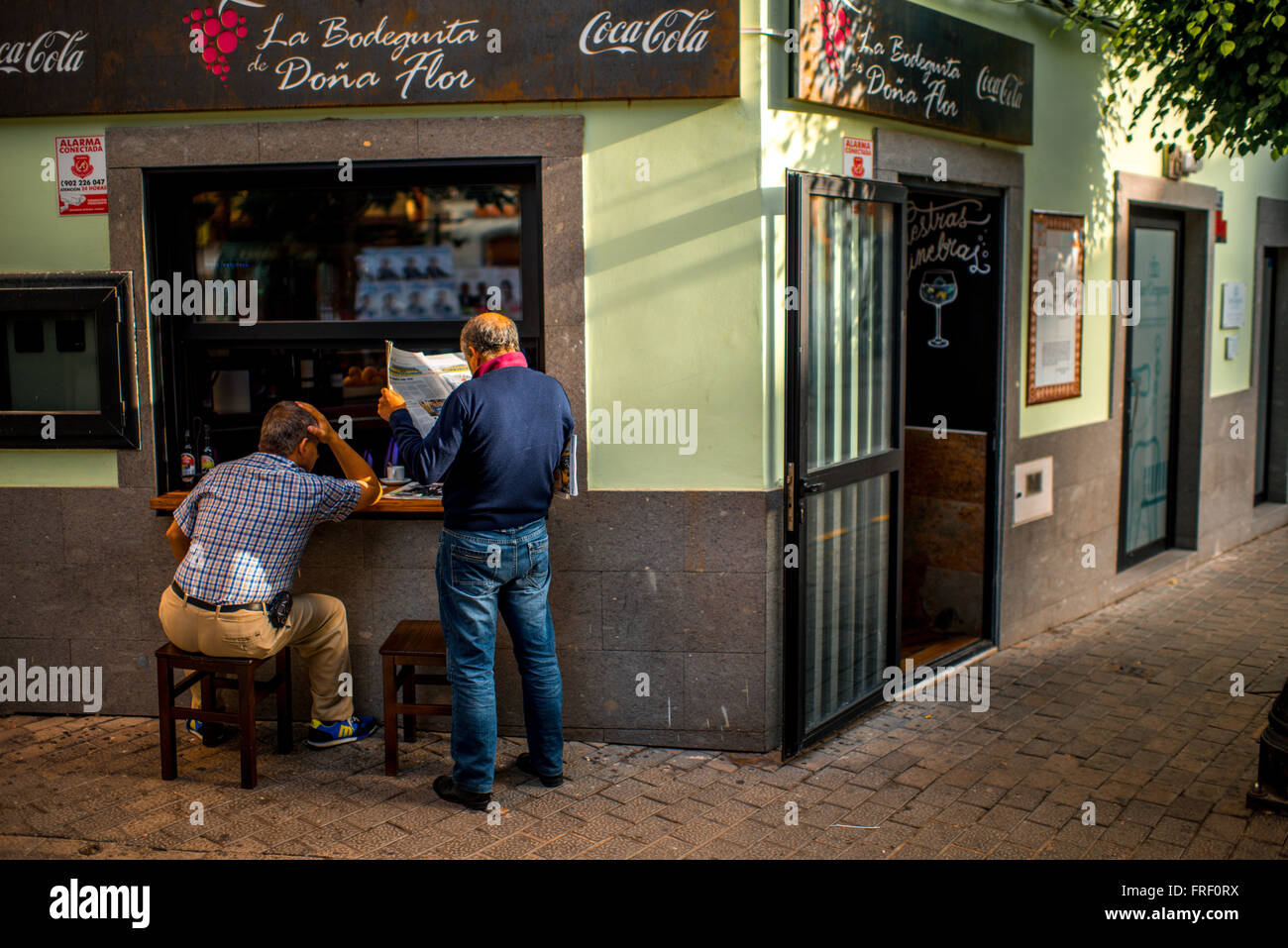 TELDE, GRAN CANARIA island, Spagna - 14 dicembre 2015: due alti uomini leggendo il giornale del mattino vicino al cafe in Telde village o Foto Stock