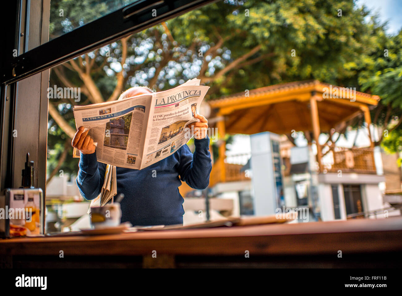 TELDE, GRAN CANARIA island, Spagna - 14 dicembre 2015: Senior uomo leggendo la Provicia giornale vicino al cafe in Telde village o Foto Stock
