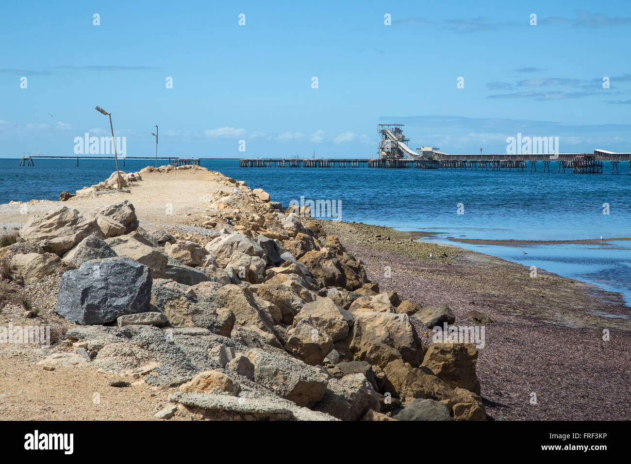 Di recente costruzione argine di roccia sporgente nel mare liscio con jetty Foto Stock