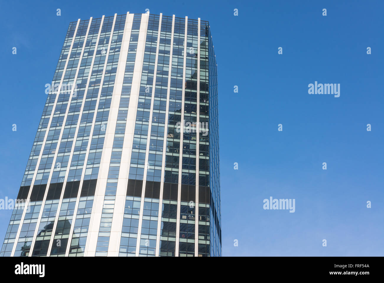 Facciata di un grattacielo in vetro con vuoto azzurro cielo in background. Foto Stock