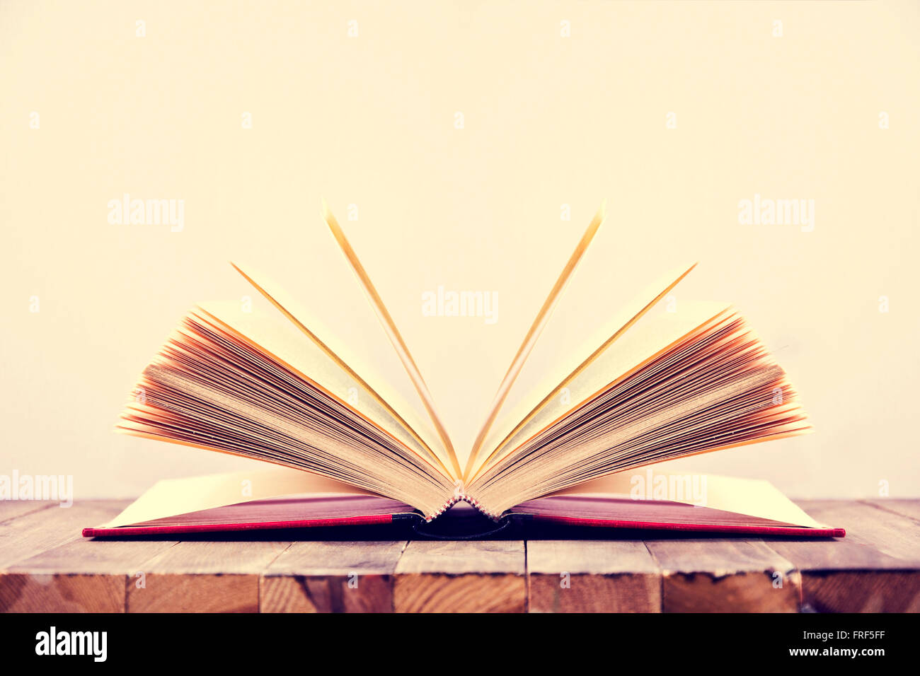 Libro Aperto sul tavolo di legno e sfondo bianco. Istruzione immagine concettuale. Foto Stock