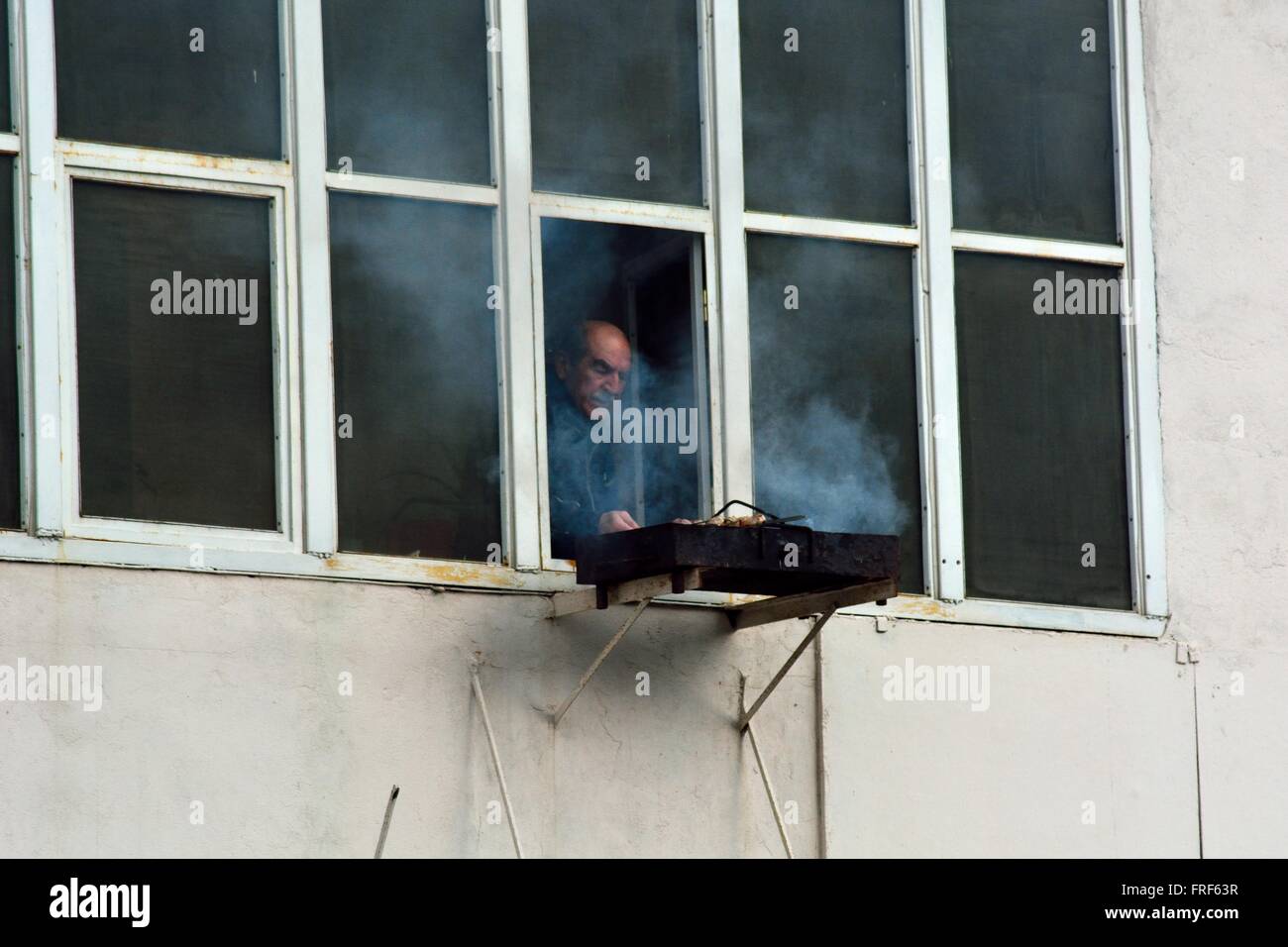 BAKU in Azerbaijan - gennaio 06 2014 l uomo alla brace da finestra di Baku, capitale dell'Azerbaigian. La cottura alla griglia in alto Foto Stock