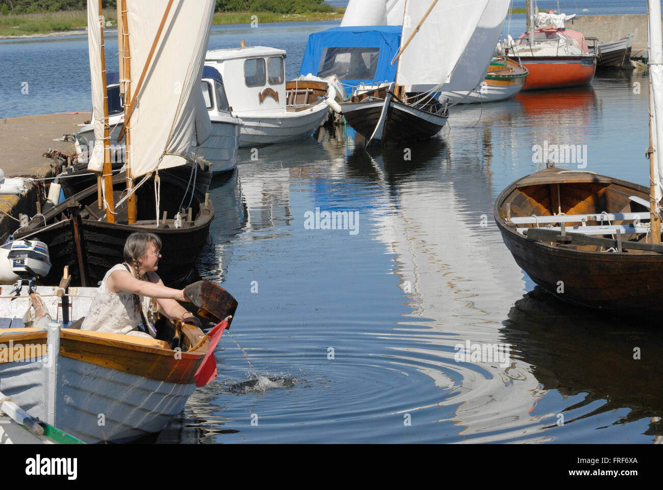 La Svezia, Gotland: Vichinghi isola. - 05/08/2007 - Europa - In un grazioso porto di pesca di isola di Gotland, una donna che drena la sua boa Foto Stock