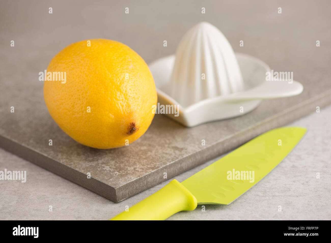 Limone, coltello spremitore e sul tavolo di cucina. Concetto di preparazione del cibo e la cucina con frutta fresca. Foto Stock