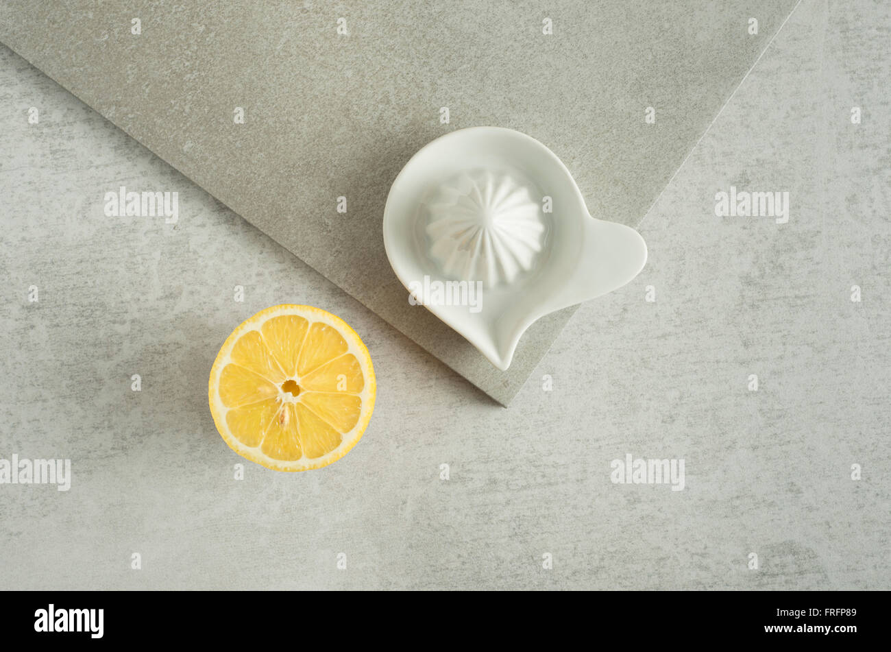 Il limone e strizzatore sul tavolo da cucina. Concetto di preparazione del cibo e la cucina con frutta fresca. Foto Stock