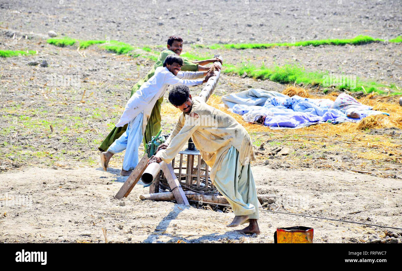 Fatiche sono occupato nella trivellazione di un tubo ben utilizzando i metodi tradizionali per ottenere acqua sotterranea per scopi di irrigazione alla vigilia della Giornata mondiale dell'acqua in campo agricolo in Larkana Martedì, Marzo 22, 2016. Foto Stock