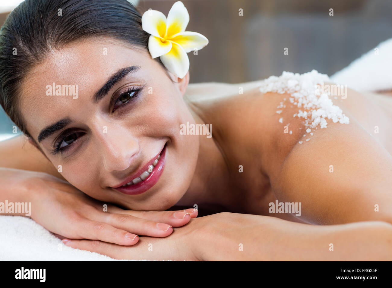 Donna sdraiata sul lettino da massaggio con scrub al sale sul retro Foto Stock