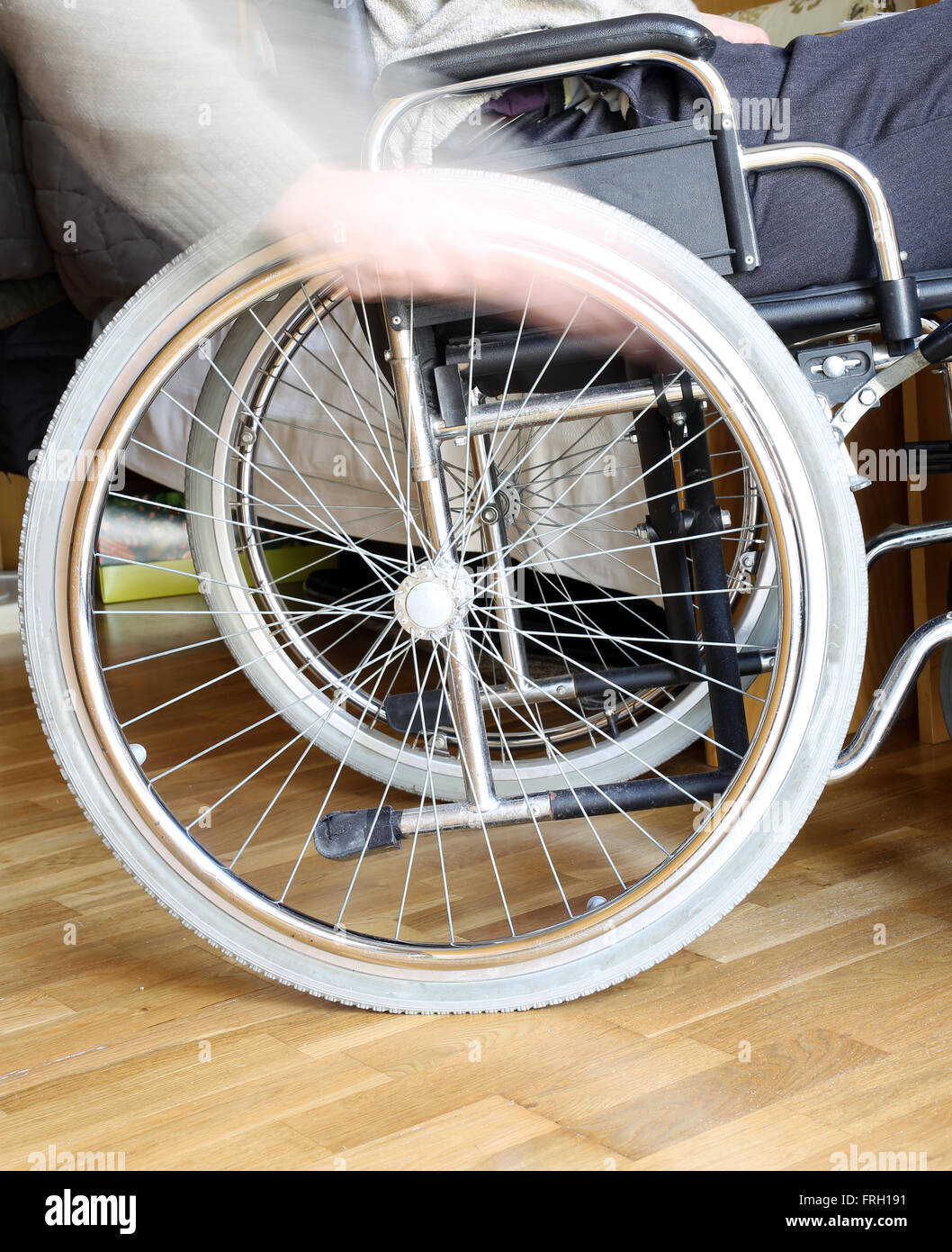 Mano di giovani disabili nella ruota della carrozzella Foto Stock