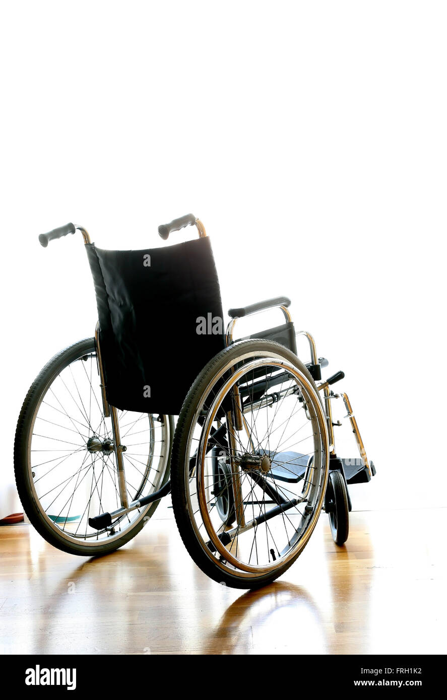 Sedia a rotelle per il trasporto di persone disabili su la camera da letto di fronte alla finestra Foto Stock