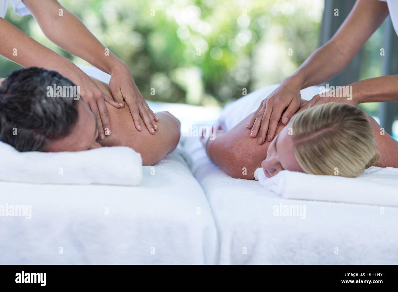 Coppia giovane ricevere un massaggio alla schiena da massaggiatore Foto Stock