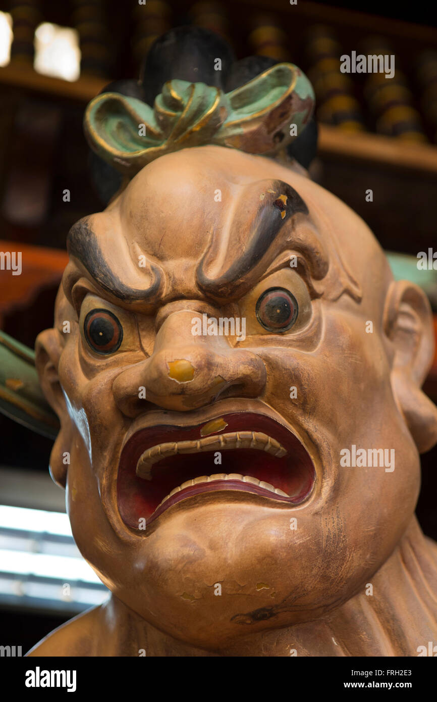 Sri Lanka, Colombo, Gangaramaya tempio, faccia distorta del demoniaco figura guardia preghiera hall Foto Stock