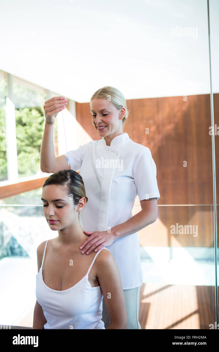 Massaggiatrice tenendo pendente sopra testa di donna Foto Stock