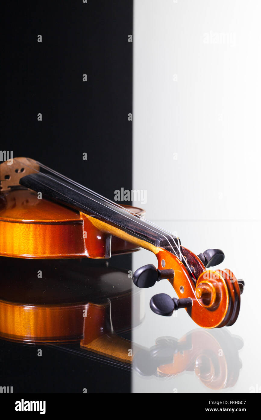 Vecchio violino isolato in bianco e nero e sfondo scrivania in vetro Foto Stock