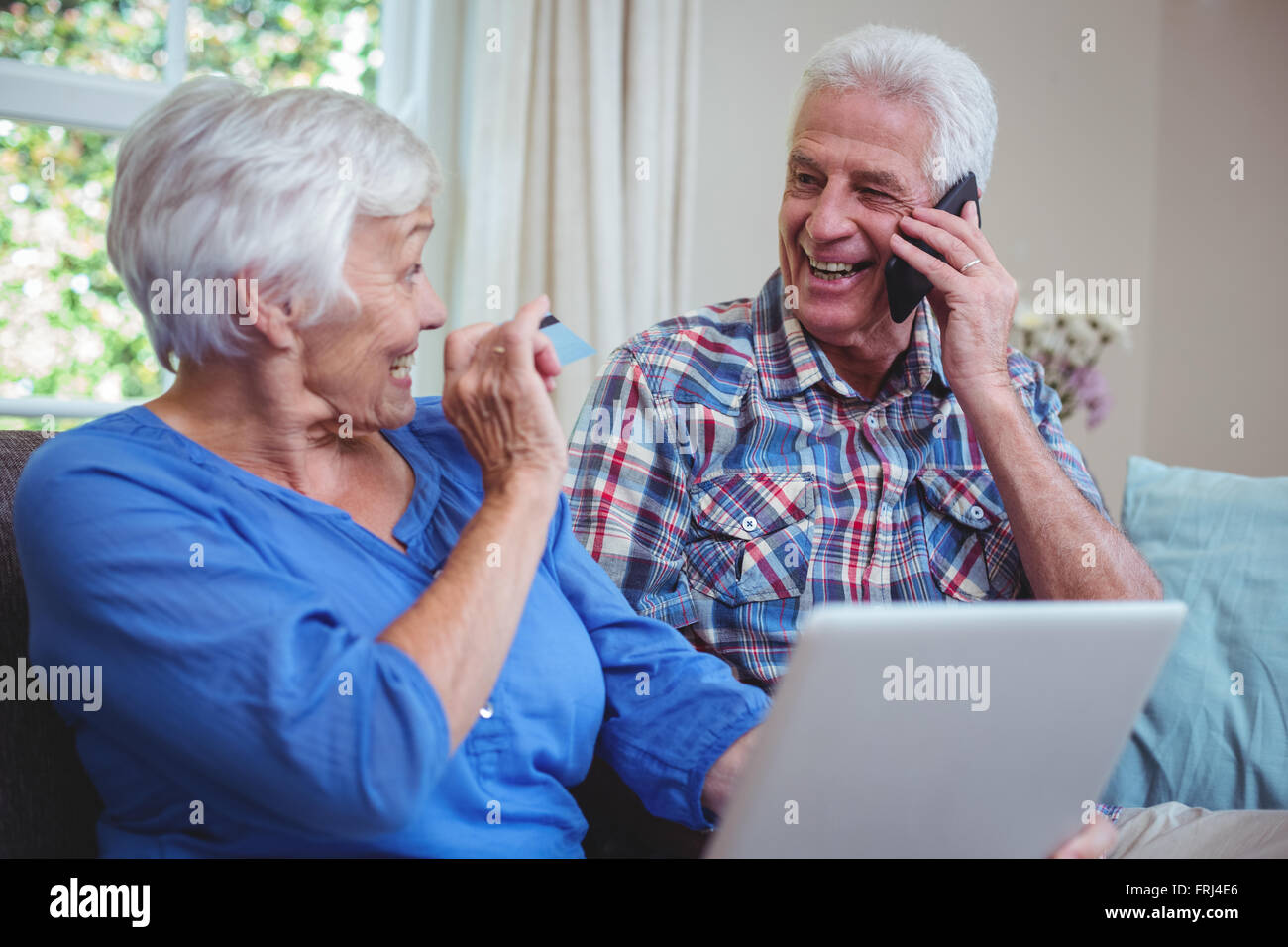 Sorridente coppia senior utilizzando la tecnologia Foto Stock