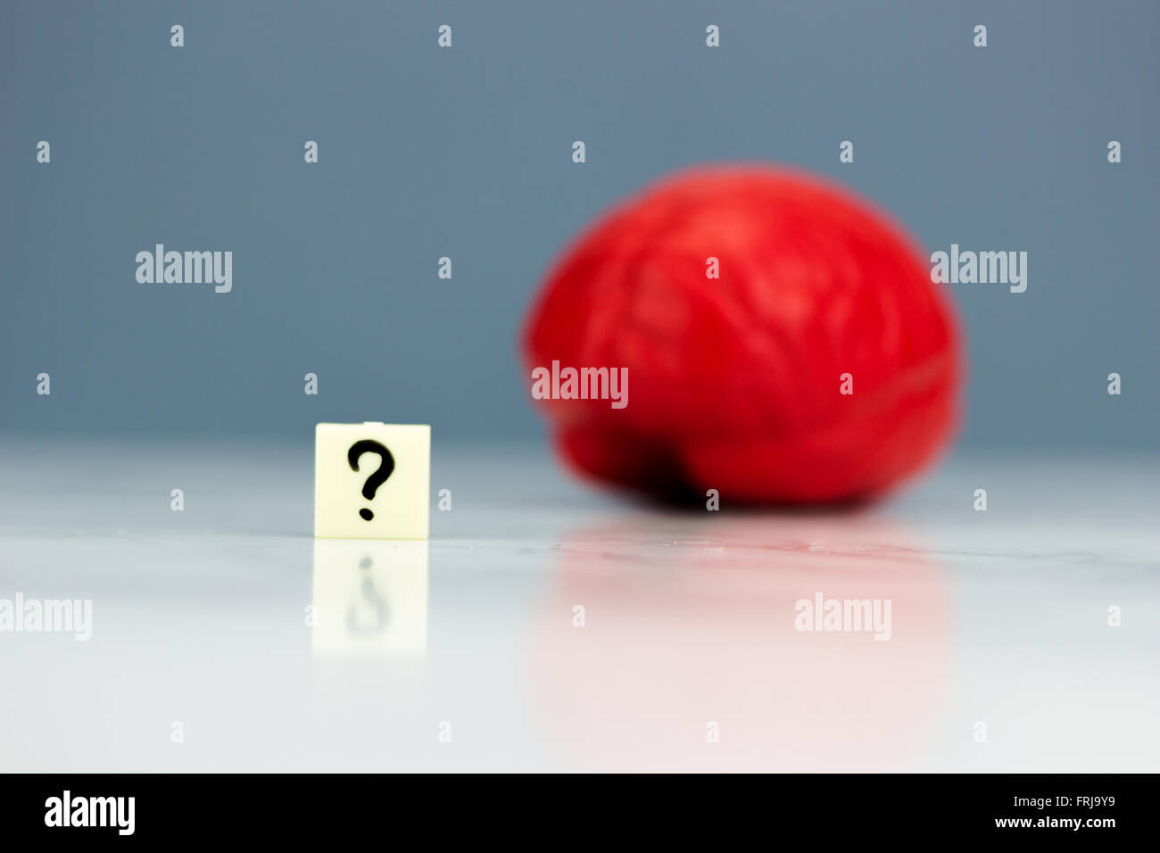 Cervello di rosso con un punto interrogativo su sfondo scuro Foto Stock