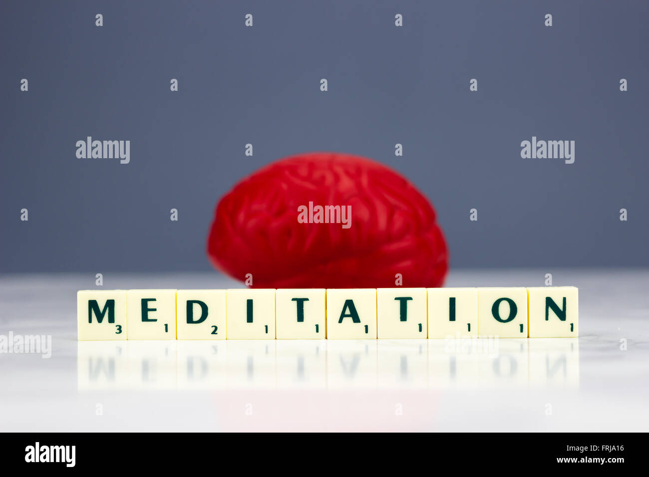 Cervello rosso con segno di meditazione su sfondo scuro Foto Stock