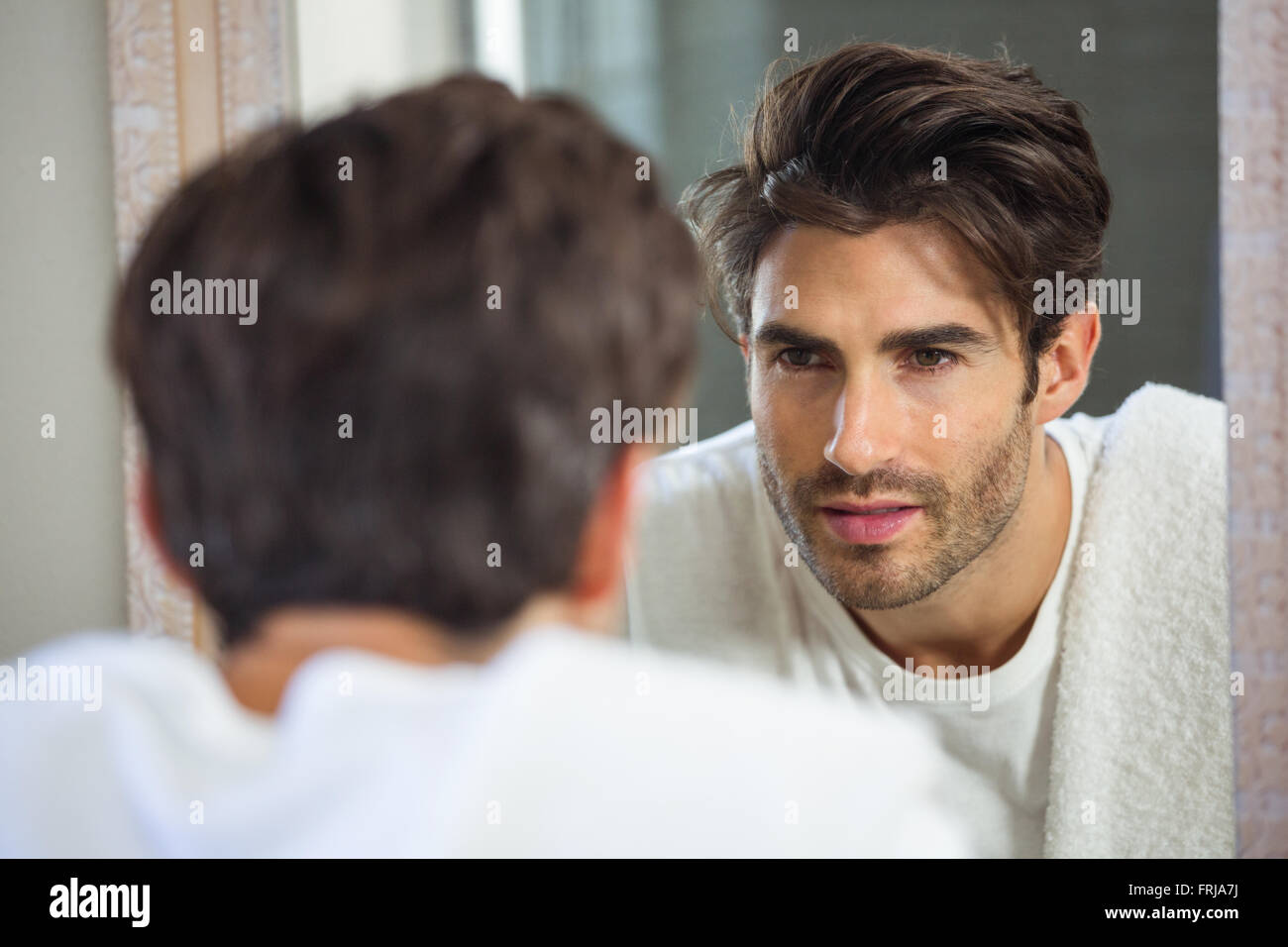 Uomo che guarda se stesso in specchio Foto Stock